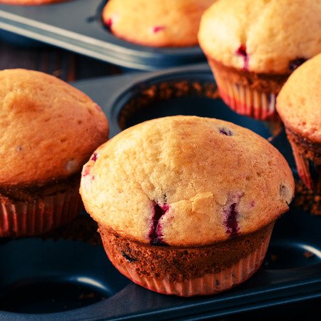 53701452 - cranberry muffins on wooden background, selective focus.